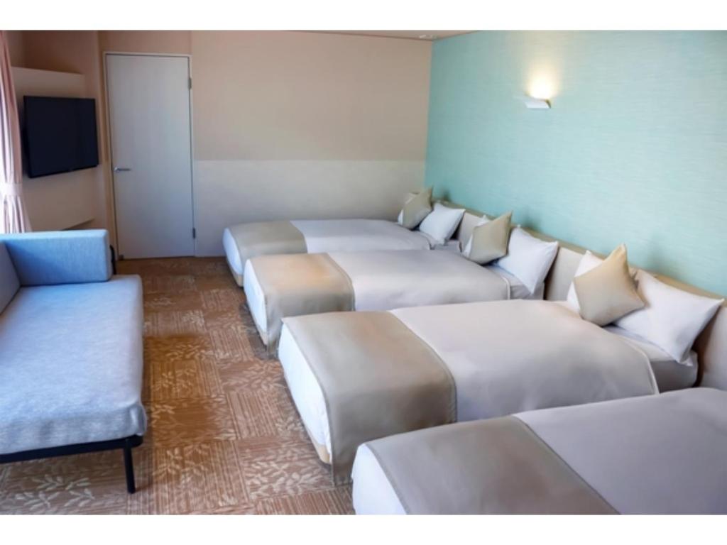 a row of beds in a room with a couch at Blanchette Nankishirahama - Vacation STAY 05732v in Kanayama