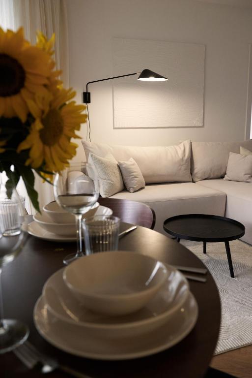 a living room with a table with plates and a couch at Apartament Sienkiewicza 22B in Zamość
