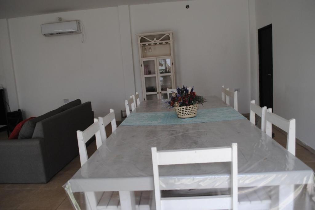 a dining room with a white table and chairs at Suinda casa de campo in Corrientes