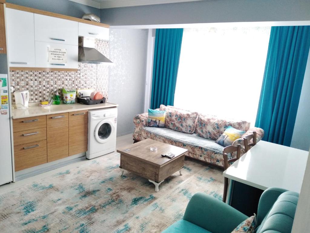 een kleine woonkamer met een bank en een tafel bij Egepar Rezidance Apart otel in Buca