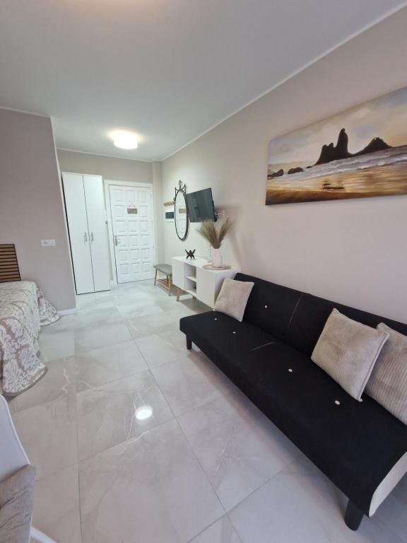 salon z czarną kanapą w pokoju w obiekcie Studia Puerto de Santiago w mieście Puerto de Santiago