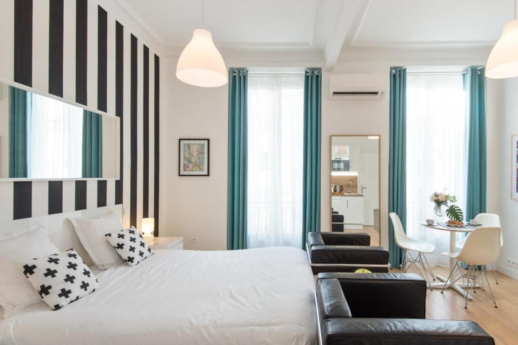 - une chambre avec un lit blanc à rayures noires et blanches dans l'établissement Le Studio Graphite Welkeys, à Nice