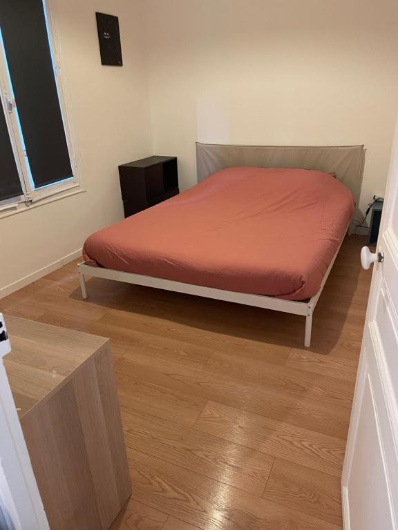 Un dormitorio con una cama con una colcha roja. en New Cosy Home, en Nogent-sur-Marne