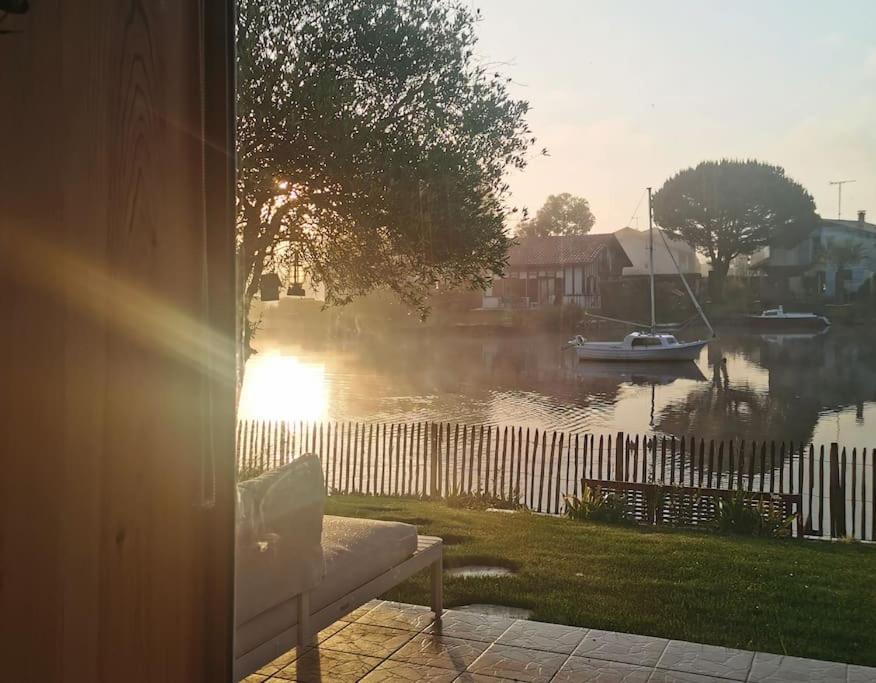 - une vue sur un lac avec un bateau dans l'eau dans l'établissement Maison au bord du lac, les pieds dans l'eau, à Soustons