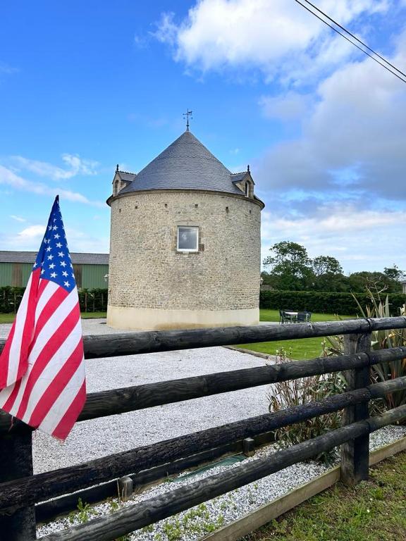 un drapeau américain sur une clôture devant un bâtiment dans l'établissement Gite MANULAU, à Turqueville