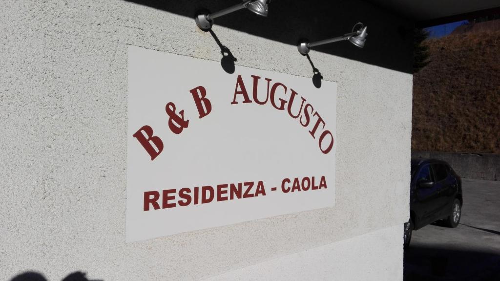 Un cartello sul lato di un edificio che legge aggressione ribelle di B&B Augusto a Madonna di Campiglio