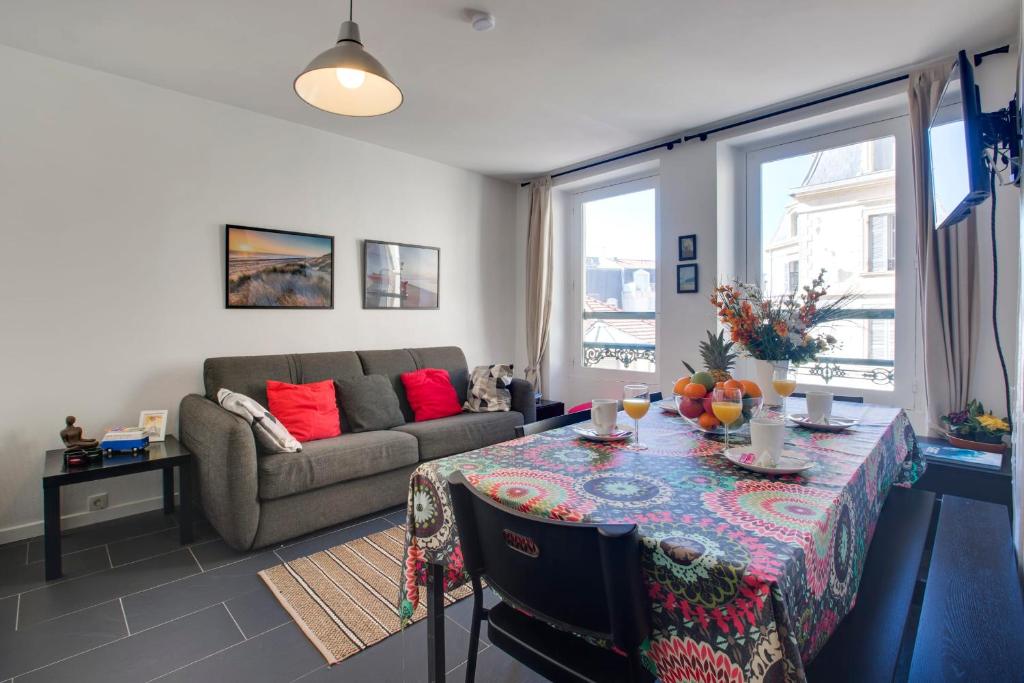 a living room with a table and a couch at Appartement Mazagran - Welkeys in Biarritz