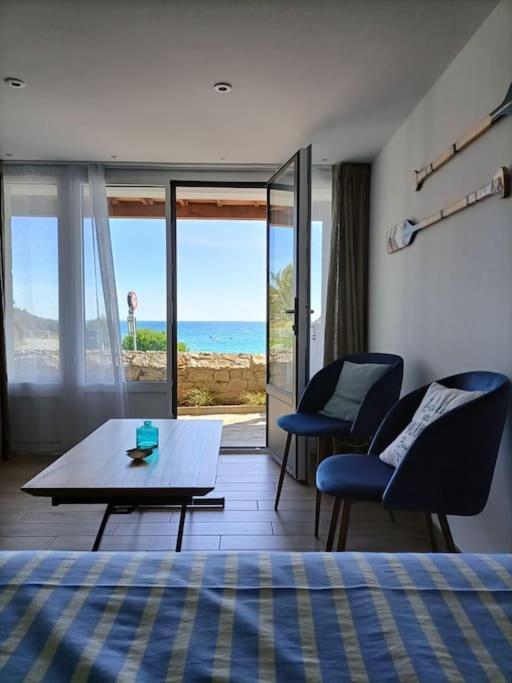 - une chambre avec une table et des chaises et une vue sur l'océan dans l'établissement Sea Lodge - Plage de Port Mer, Cancale, à Cancale