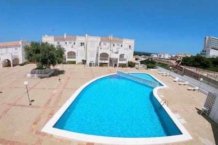a large blue swimming pool in front of a building at Gregal - Castell Sol - Arenal de Castell in Arenal d'en Castell