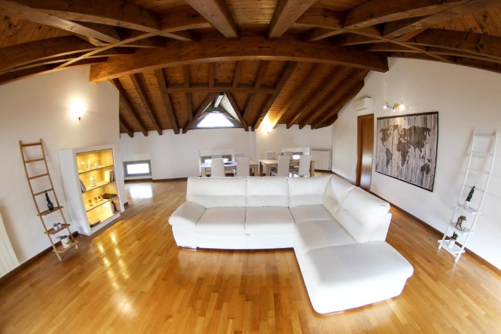 a living room with white furniture and a wooden ceiling at Donizetti Royal in Bergamo