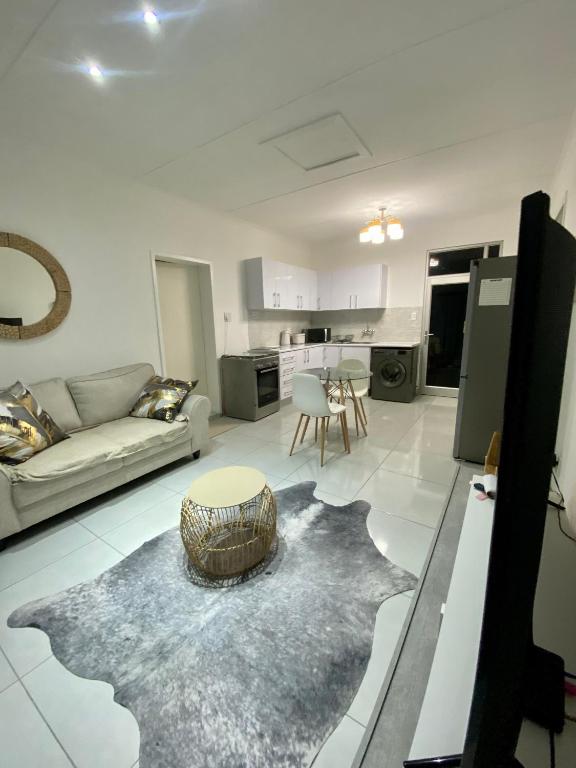 a living room with a couch and a table at Zahara Cousy Home in Windhoek