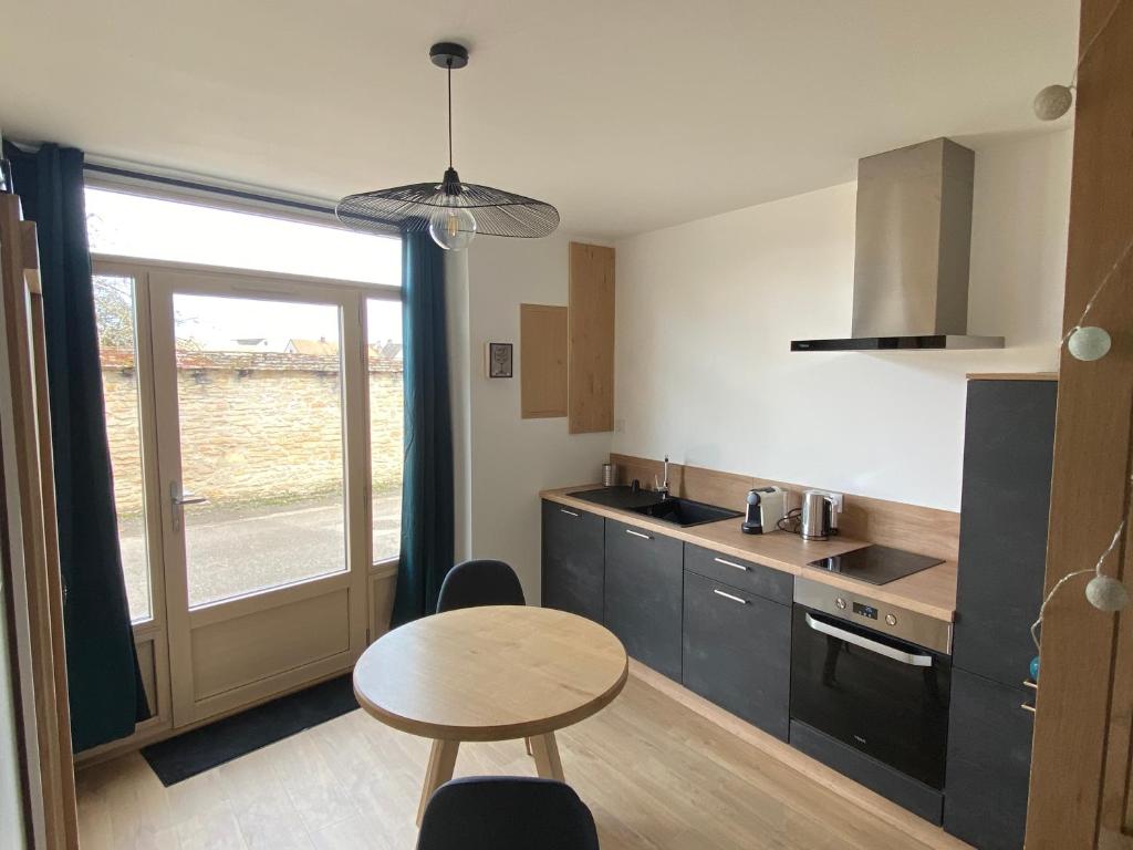 une cuisine avec une table et une petite table avec des chaises dans l'établissement Au studio cosy, à Chorey-lès-Beaune