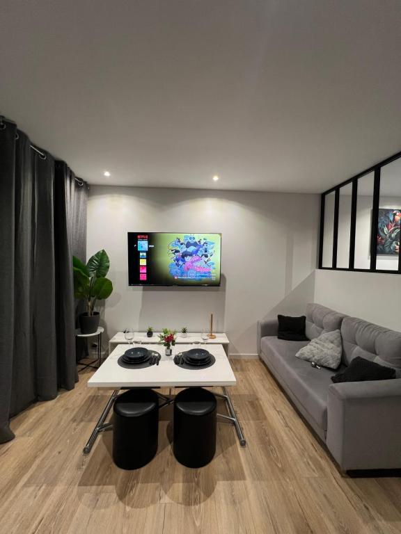 un salon avec une table blanche et un canapé dans l'établissement Studio Relax, à Rouen