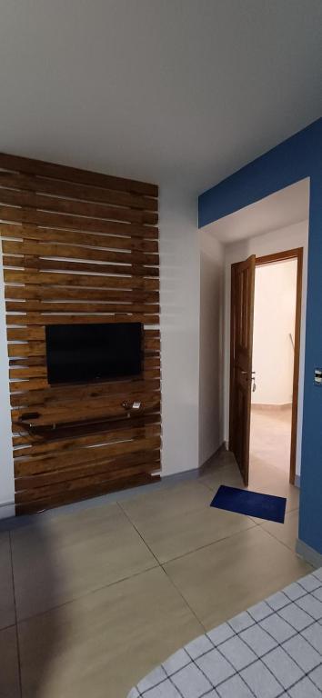 a living room with a flat screen tv on a wall at Loft 02 in Bombinhas