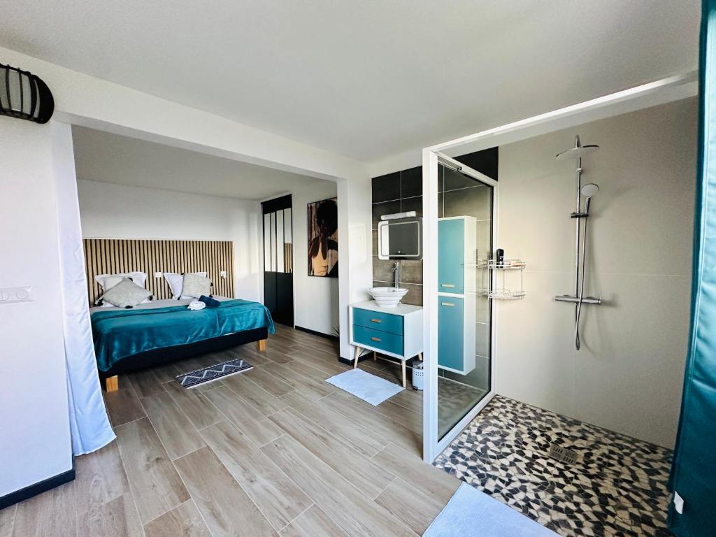 a bedroom with a bed and a bathroom with a sink at Sweety blue, vue mer in Les Trois-Îlets