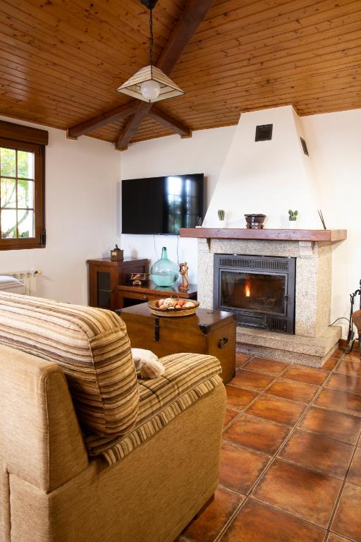 a living room with a couch and a fireplace at Villa Laudina in Vilaboa