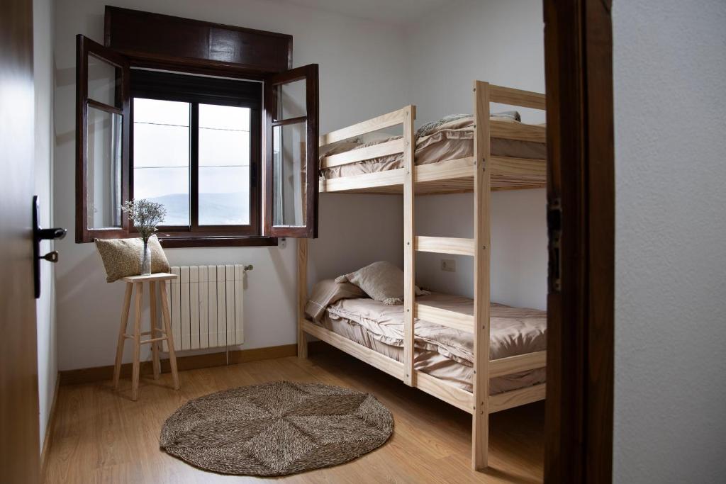 Un dormitorio con dos literas y una ventana. en Villa Laudina, en Vilaboa