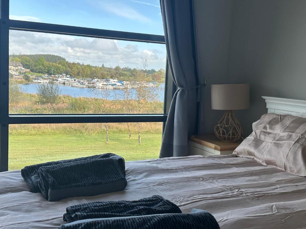 a bedroom with a bed with a large window at Luxury 3 bed property overlooking River Erne Marina in Belturbet