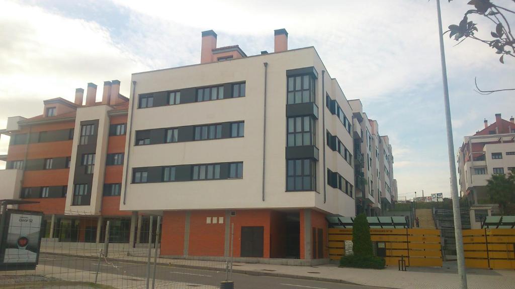 a tall white building on the side of a street at Mar Cantabrico Apartment in Gijón