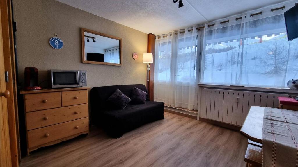 un salon avec une chaise et une télévision dans l'établissement Résidence La Taiga - Résidence TAIGA N°R2 MAE-1481, à La Plagne Tarentaise