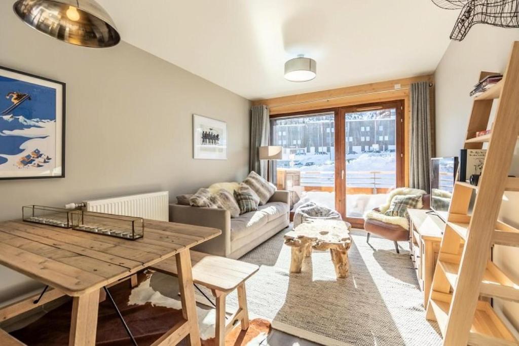 un salon avec une table et un canapé dans l'établissement Résidence Lodges 1970 - Résidence LES LODGES 1970 N°B503 MAE-1531, à La Plagne Tarentaise