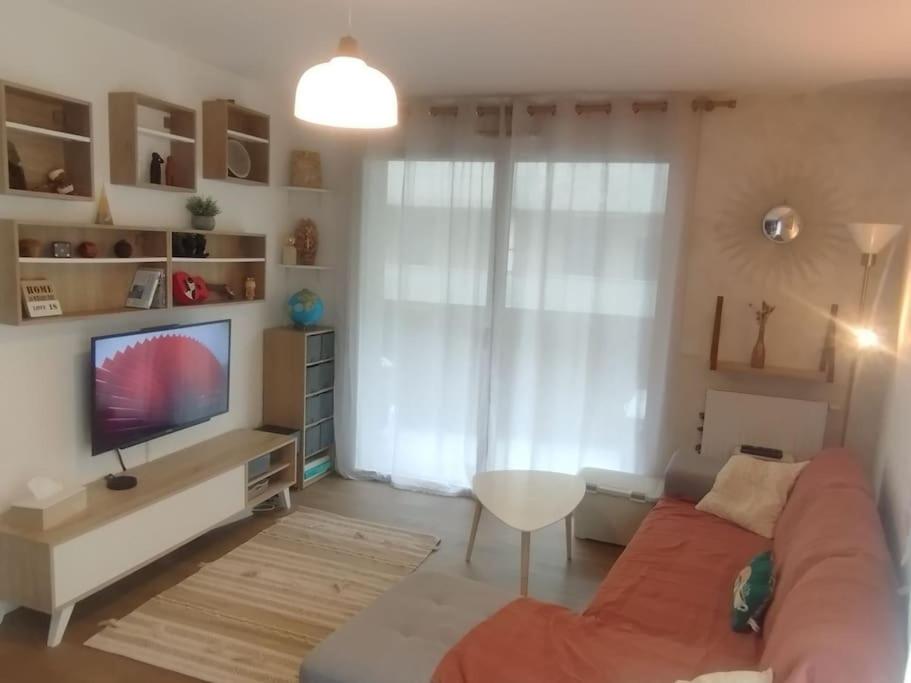 un salon avec un canapé et une télévision à écran plat dans l'établissement Proche Cité du vin - idéal famille - Parking privé, à Bordeaux