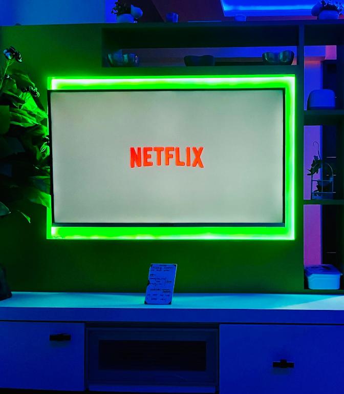 a television screen with a netflix sign on it at 7 Seasons Palm Suite with Sky Orbit, Balcony, Swimming pool, WIFI, Playground in Rajkot