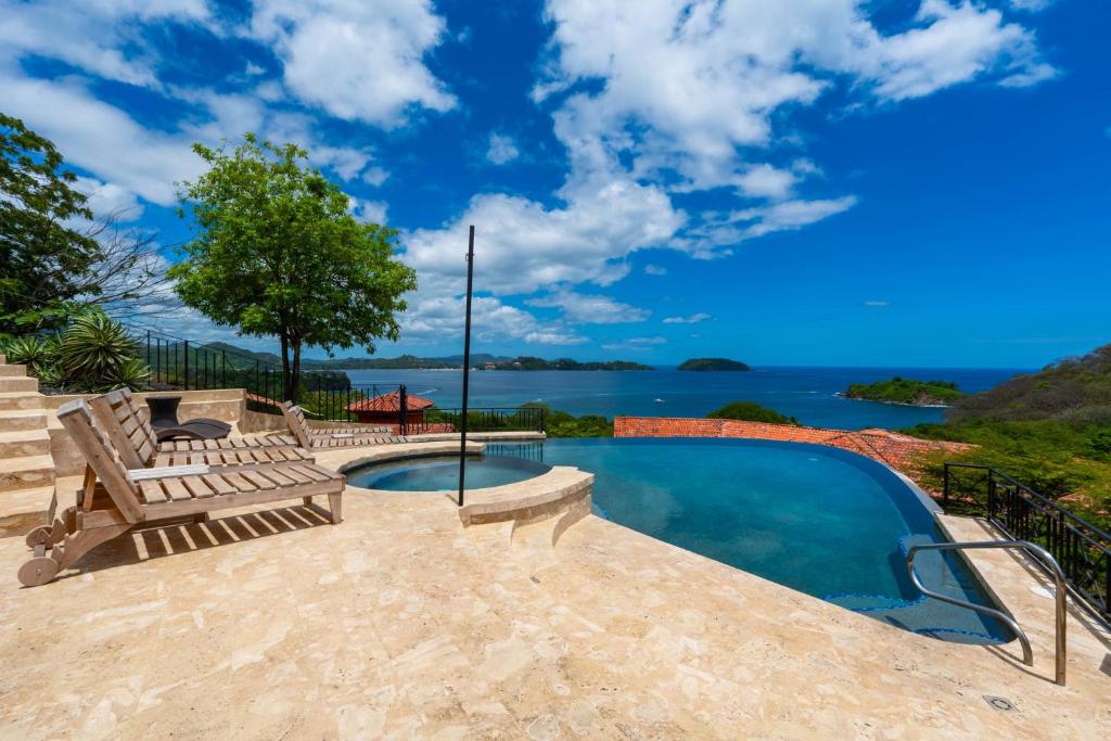 a swimming pool with a bench and a view of the water at Infinity Pool, Pacific Views & Concierge in Potrero