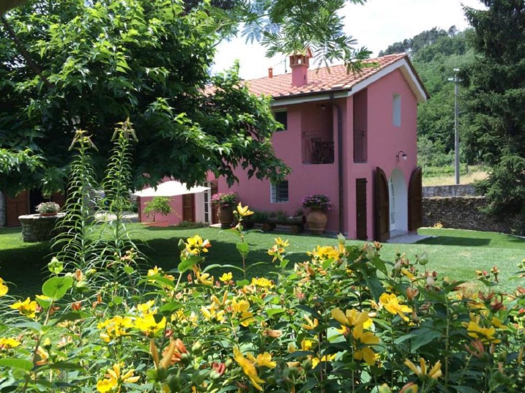 una casa rosa con flores amarillas delante de ella en Agriturismo Terrarossa en Pistoia