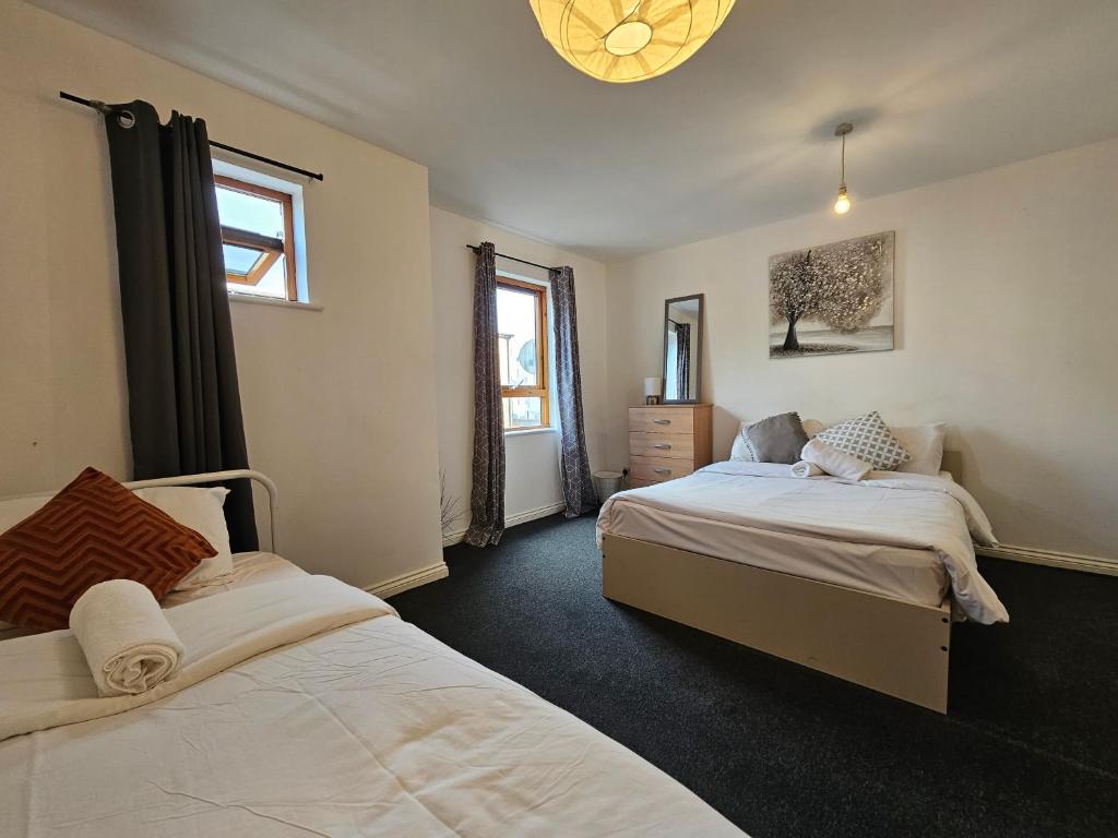 a bedroom with two beds and a chandelier at All saints Rooms in London