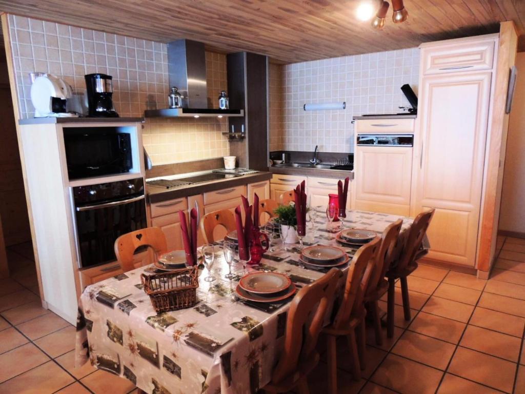 une cuisine avec une table et des chaises ainsi qu'une cuisine avec une table et des chaises dans l'établissement Résidence Lou Baitandys - Plein centre, skis aux pieds, vue dégagée sur pistes MAE-0851, aux Gets