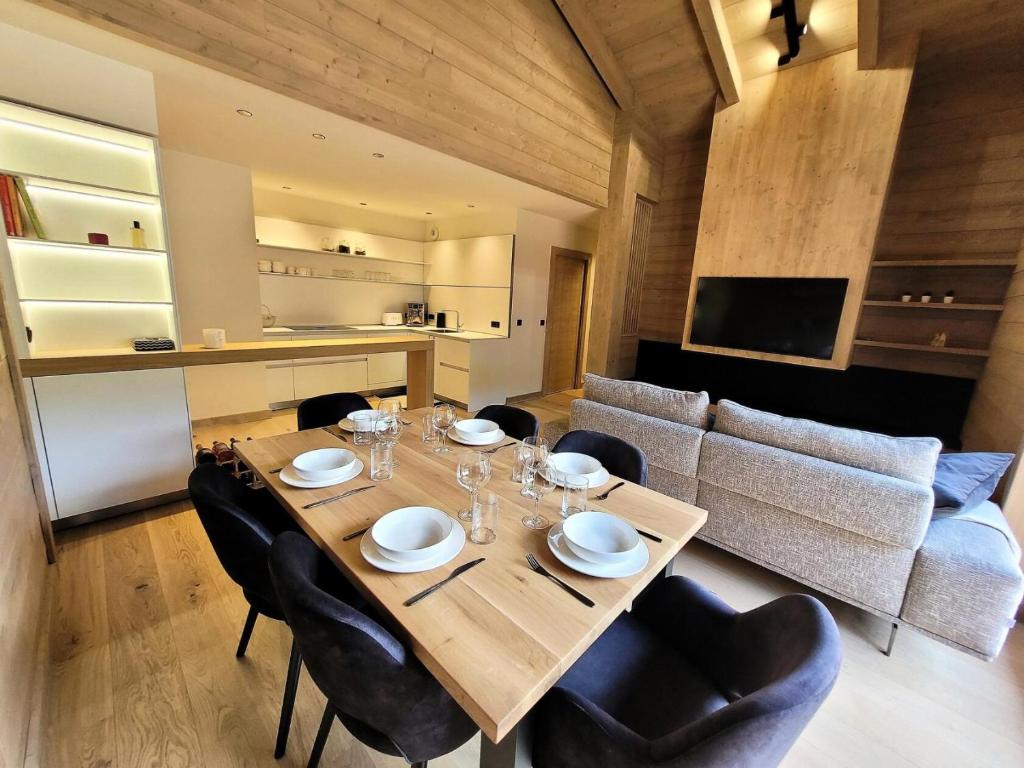 une salle à manger avec une table et des chaises en bois dans l'établissement Résidence Le Stella - Elégance et confort au coeur du village MAE-1031, aux Gets