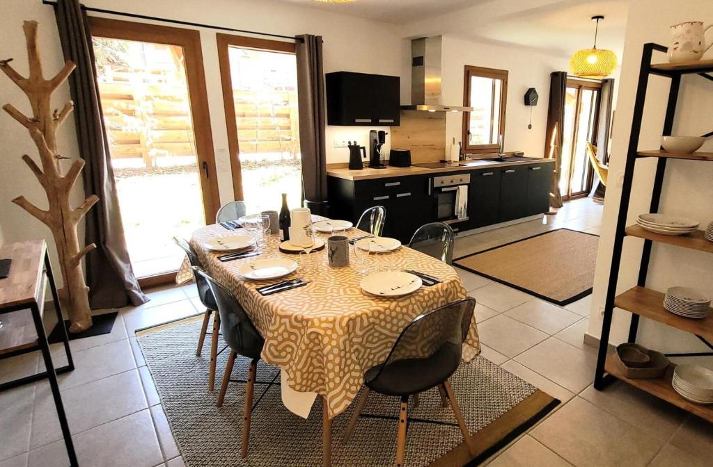 une table de salle à manger avec des chaises et une cuisine dans l'établissement Chalet Ines - Appartement spacieux avec jardin MAE-0921, aux Gets
