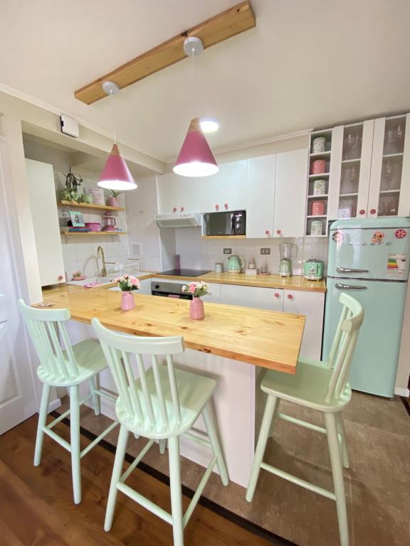 a kitchen with a wooden table and four chairs at Departamento rosado in Puerto Montt