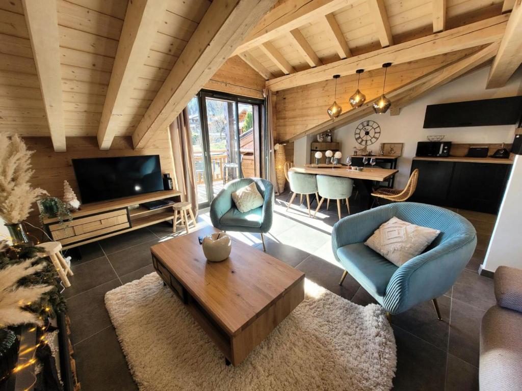 un salon avec un canapé et une table dans l'établissement Résidence Le Hameau Des Cornuts - Vivez un séjour de charme dans cet appartement sous toit MAE-1021, aux Gets