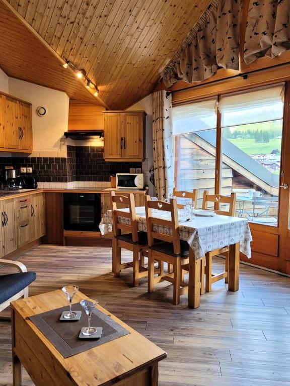 une cuisine et une salle à manger avec une table et des chaises dans l'établissement Résidence La Bouillandire - Appartement lumineux avec vue imprenable MAE-1121, aux Gets
