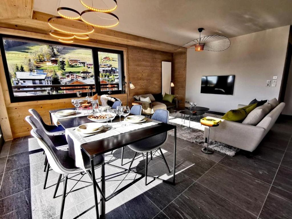 un salon avec une table à manger et un canapé dans l'établissement Chalet 1839 - Superbe appartement coeur de station, pied des pistes MAE-0901, aux Gets