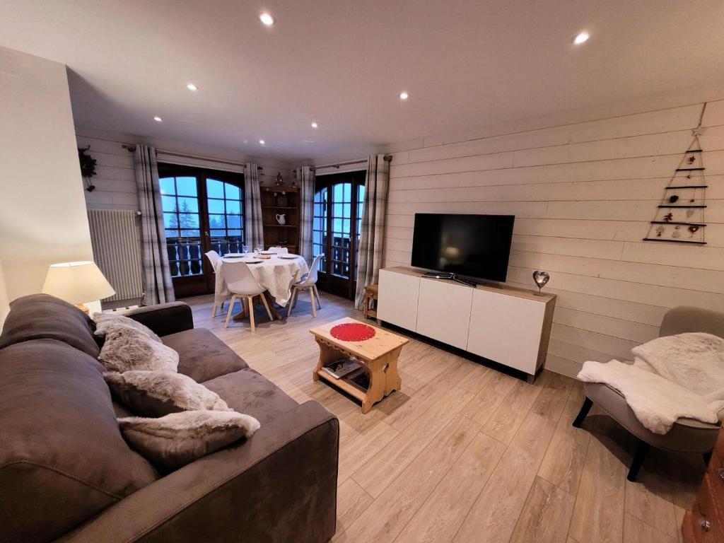 un salon avec un canapé, une télévision et une table dans l'établissement Résidence Helios - Bel appartement rénové, au calme et proche du centre MAE-1251, aux Gets