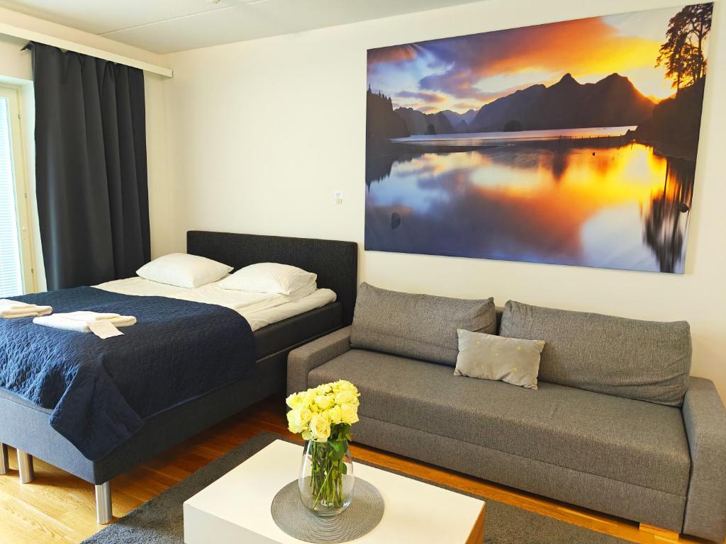 un salon avec un lit et un canapé dans l'établissement Railway station & Central studio, à Oulu