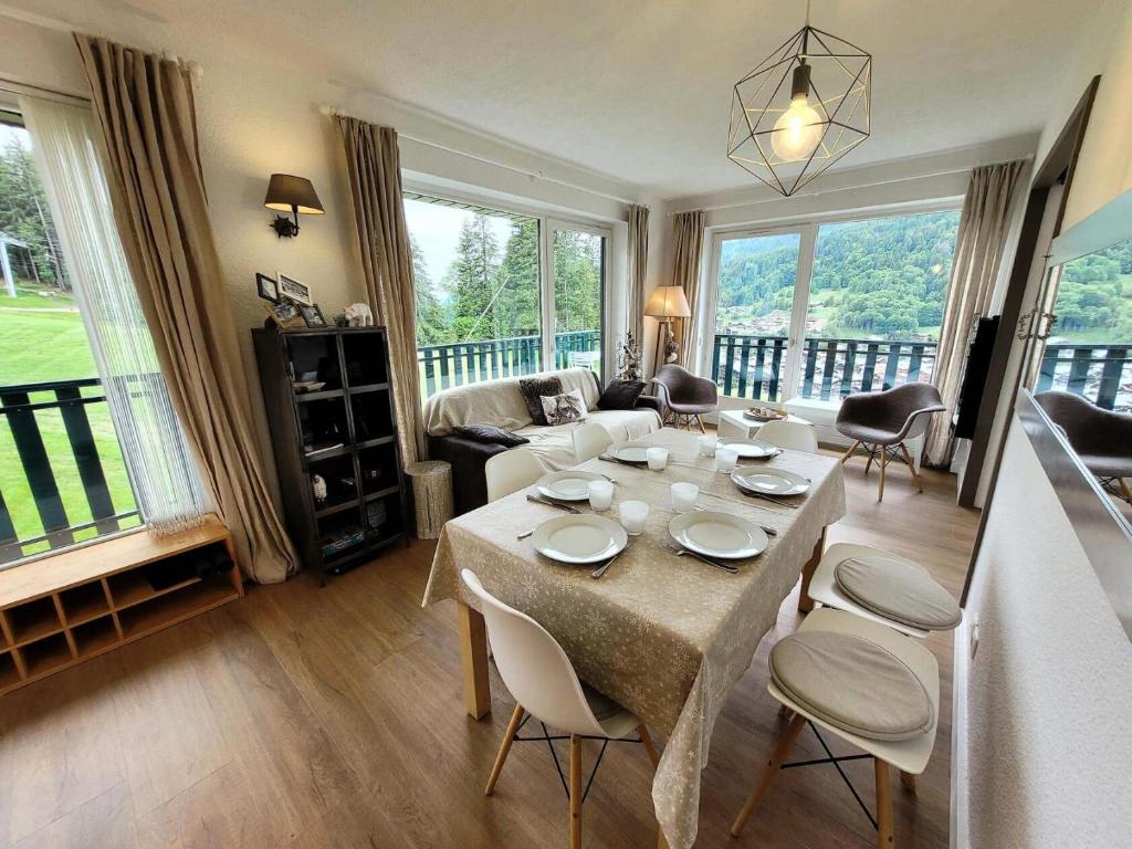 un salon avec une table avec des chaises et un canapé dans l'établissement Résidence Grizzly - Appartement skis aux pieds, entièrement rénové MAE-1051, aux Gets