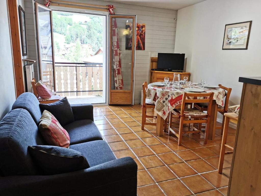 un salon avec une table et un canapé bleu dans l'établissement Résidence Saint Guibert - Appartement au coeur du vieux village MAE-1261, aux Gets