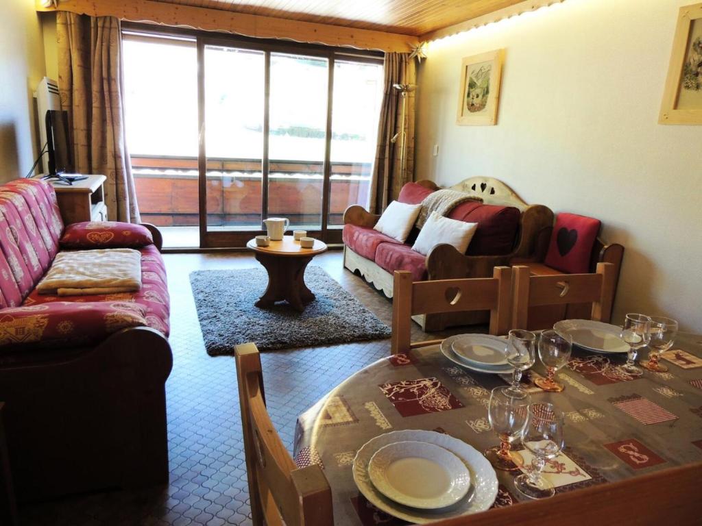 un salon avec une table et un canapé dans l'établissement Résidence Lou Baitandys - Lou Baitandys - T2 au pied des pistes et au centre du village MAE-1321, aux Gets
