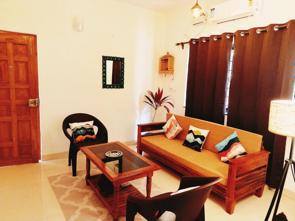 un soggiorno con un divano e un tavolo di Goan Hideaway Uno a Siolim