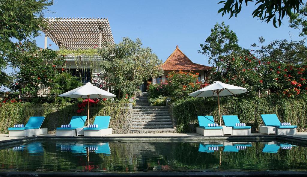 a group of chairs and umbrellas next to a pool at Bangsring Breeze in Banyuwangi