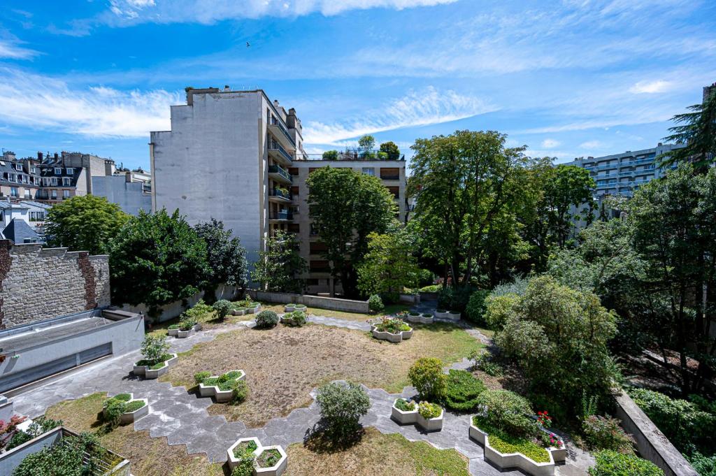 un jardin avec des plantes et des arbres dans un bâtiment dans l'établissement Trendy ,quit and chic, à Paris