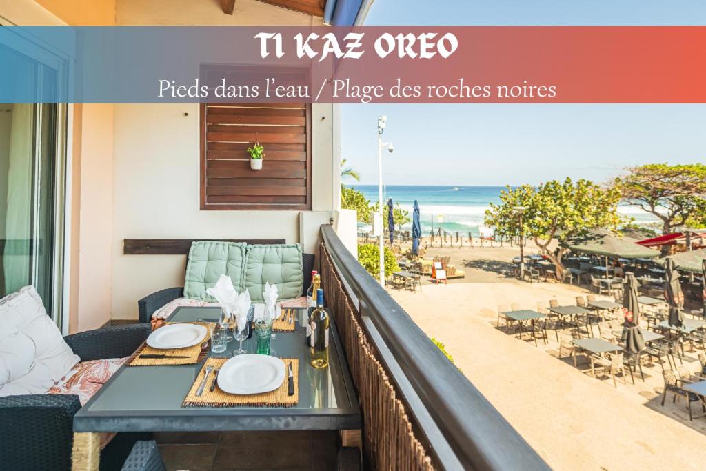 a table on a balcony with a view of the beach at Ti Kaz Oreo - Cosy Plage & confort - Wiskeys in Saint-Gilles les Bains