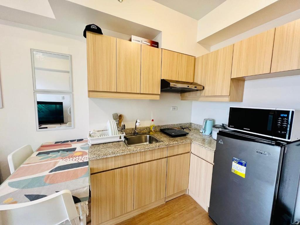 a small kitchen with a sink and a refrigerator at The Celandine Balintawak Quezon City in Manila