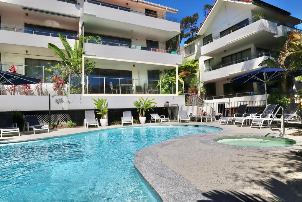 a swimming pool in front of a building at Chic 2 bdrm Poolside Apartment in Noosa Heads
