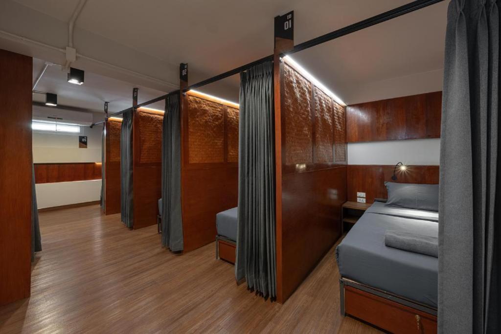 a bedroom with a bed with wooden walls and wooden floors at Ed Hostel Rachamakka in Chiang Mai