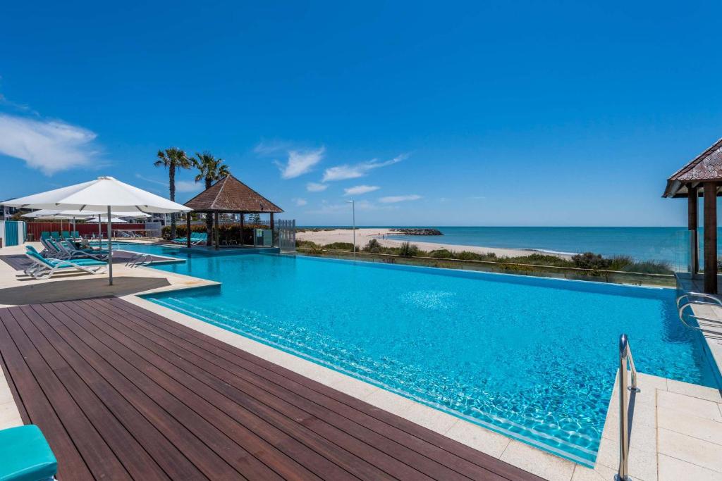 a swimming pool with a view of the ocean at 5 Star Mandurah Beach Exclusive Apt in Mandurah